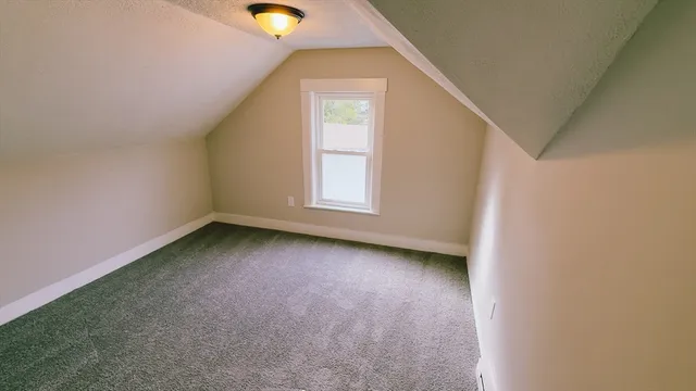 a view of hallway with window and wooden floor