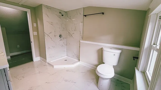 a bathroom with a sink toilet and window