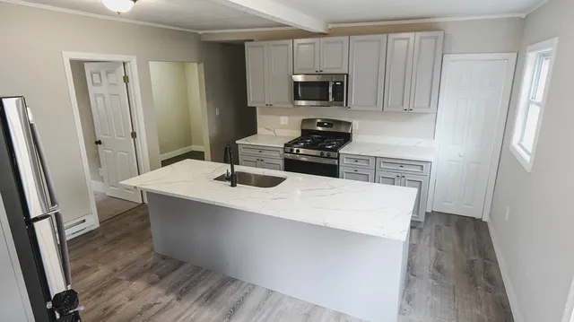 a kitchen with kitchen island a sink stove and refrigerator