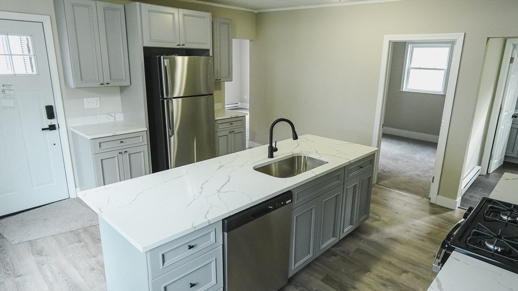 26 Maple Street Spencer, MA 01562 - Photo 4 of 27 a kitchen with a sink a refrigerator and cabinets
