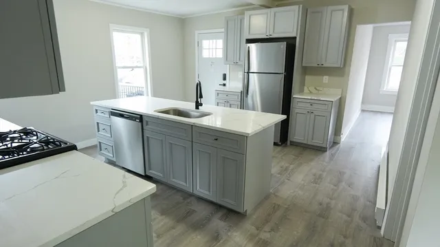 a kitchen with white cabinets and stainless steel appliances