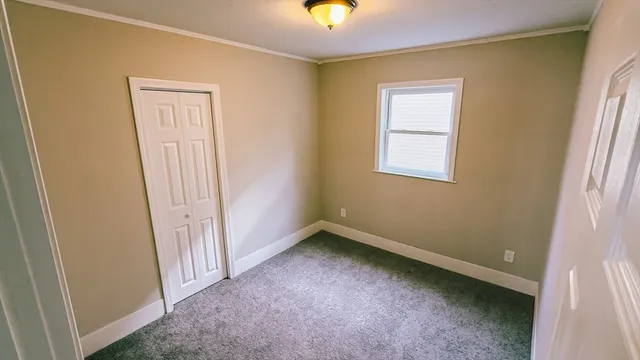 an empty room with windows and closet