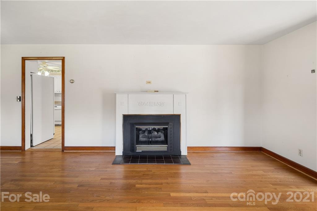 85 Walnut Ford Road Clyde, NC 28721 - Photo 12 of 24 a view of an empty room with wooden floor and a fireplace