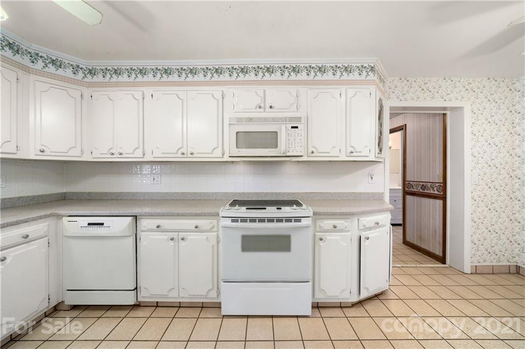 85 Walnut Ford Road Clyde, NC 28721 - Photo 13 of 24 a kitchen with cabinets a stove and a microwave