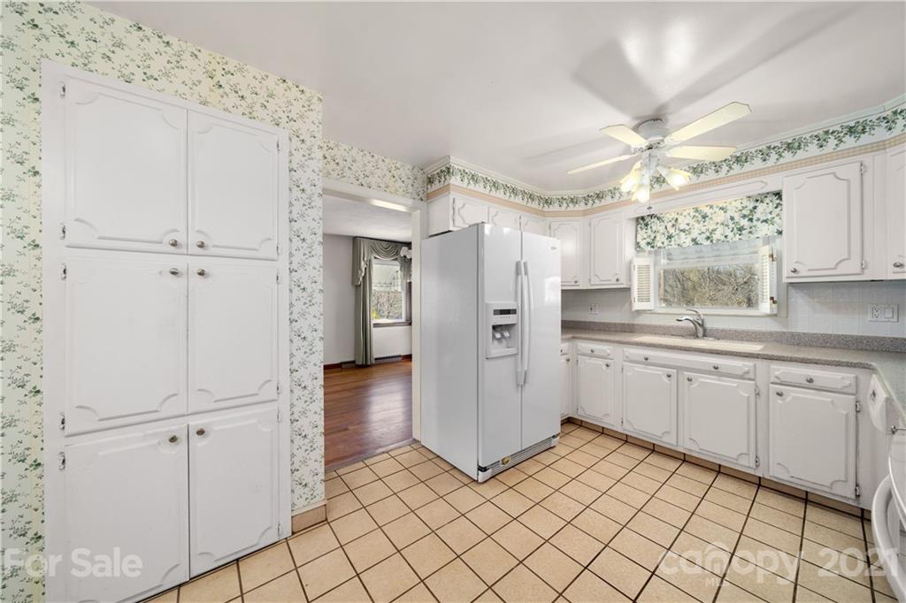85 Walnut Ford Road Clyde, NC 28721 - Photo 16 of 24 a kitchen with white cabinets and white appliances
