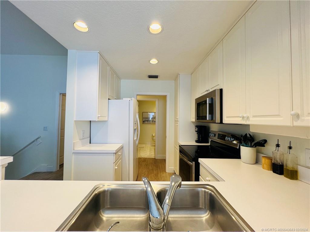 411 Northeast Plantation Road, Unit 526 Stuart, FL 34996 - Photo 15 of 76 a kitchen with a sink a counter top space stainless steel appliances and cabinets