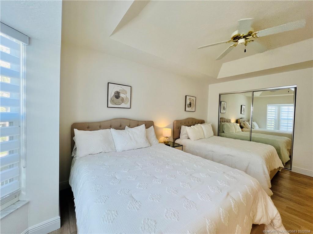411 Northeast Plantation Road, Unit 526 Stuart, FL 34996 - Photo 40 of 76 a bed room with a bed and a chandelier