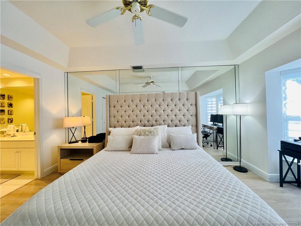 411 Northeast Plantation Road, Unit 526 Stuart, FL 34996 - Photo 50 of 76 a bedroom with a bed and a chandelier