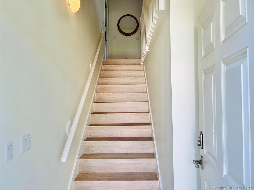 411 Northeast Plantation Road, Unit 526 Stuart, FL 34996 - Photo 6 of 76 a view of a hallway with wooden floor and staircase
