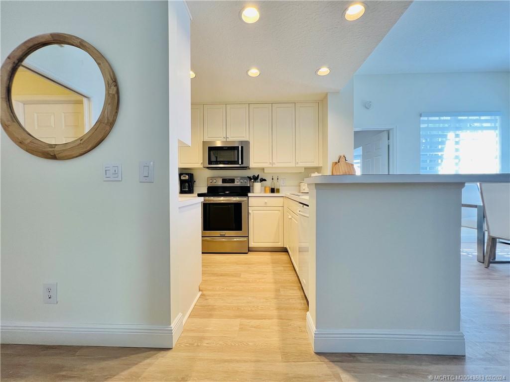 411 Northeast Plantation Road, Unit 526 Stuart, FL 34996 - Photo 10 of 76 a kitchen with stainless steel appliances granite countertop a stove a sink and a microwave