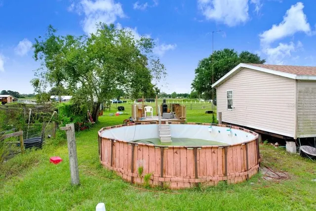 a view of a backyard with swimming pool