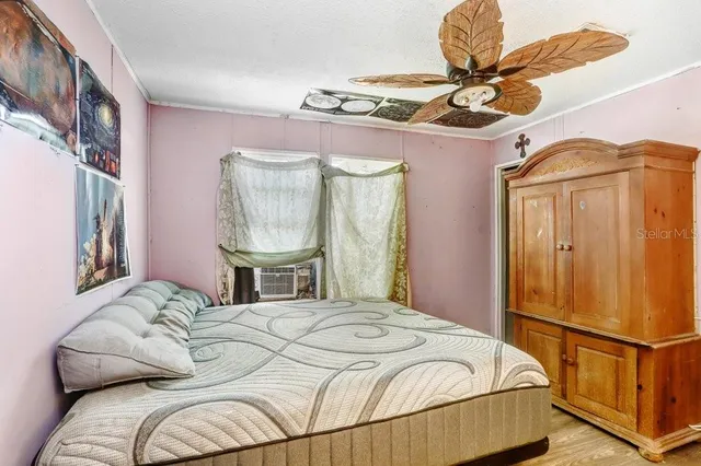 a bedroom with a bed dresser and window