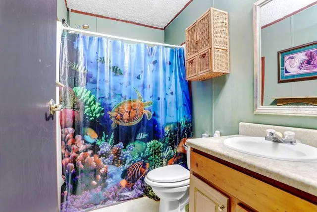 a bathroom with a granite countertop sink and a blue curtain