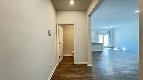 a view of a hallway with wooden floor and staircase