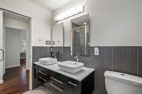 a bathroom with a sink a toilet a mirror and shower