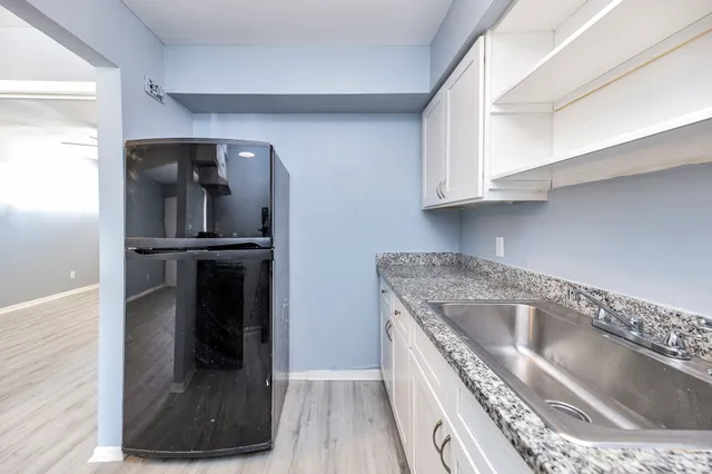 a kitchen with white cabinets and a stove top oven