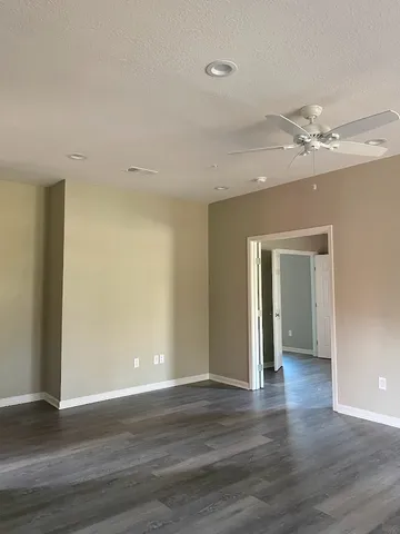 a view of an empty room with wooden floor