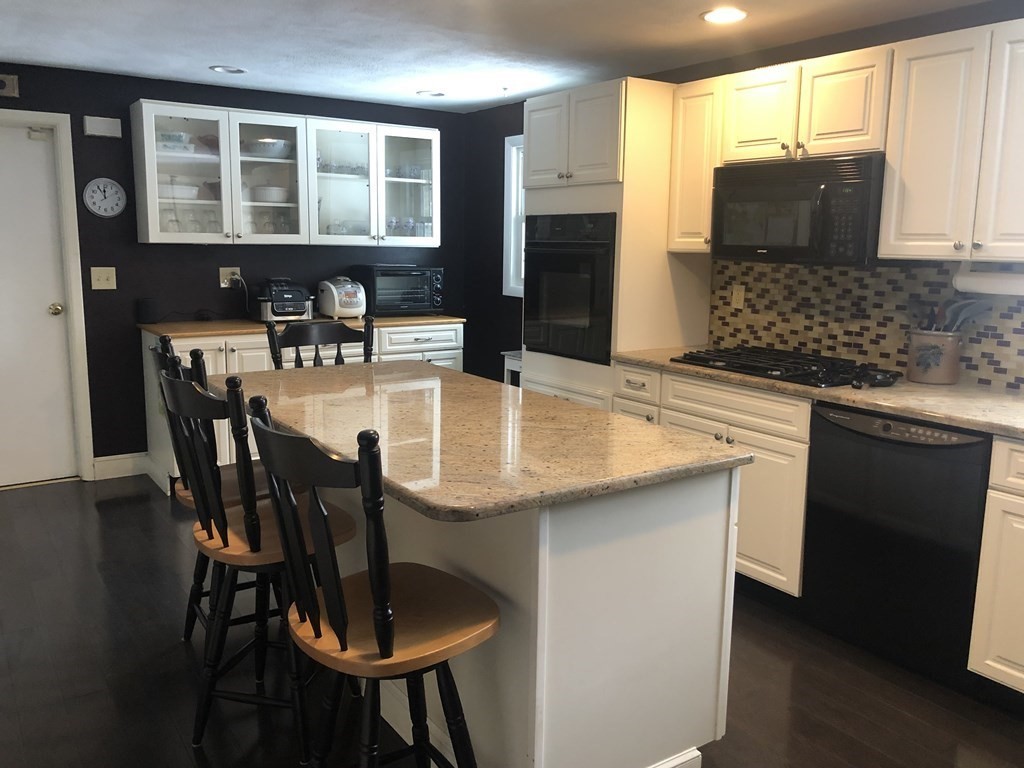 74 Old Stage Road Chelmsford, MA 01824 - Photo 8 of 33 a kitchen with stainless steel appliances granite countertop a table chairs and a refrigerator