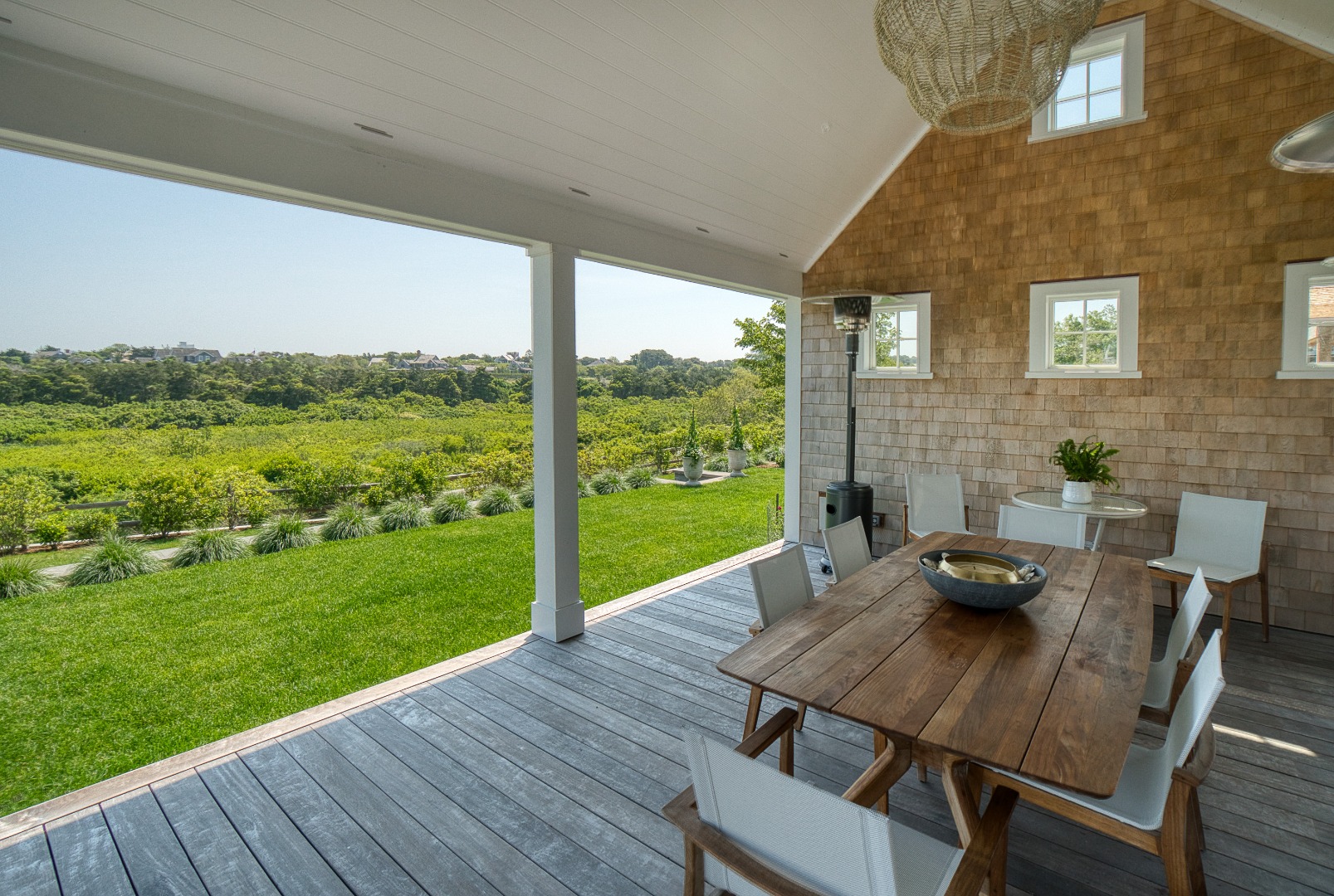 41 Monomoy Road Nantucket, MA 02554 - Photo 8 of 54 a view of a deck with table and chairs potted plants with wooden floor and fence