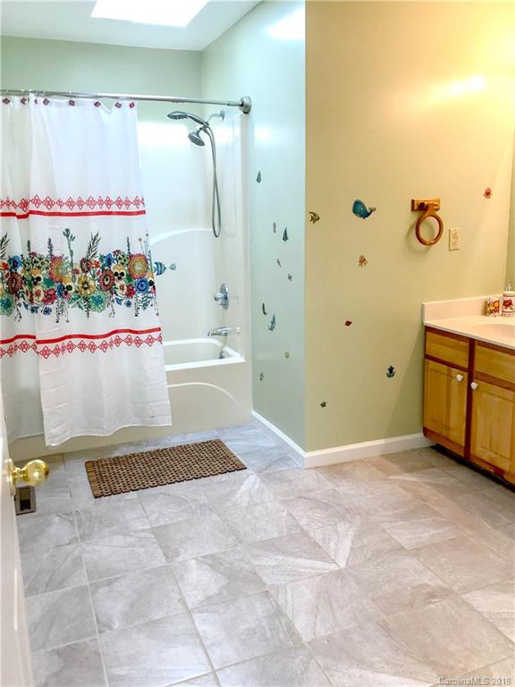 282 Fox Creek Road Mars Hill, NC 28754 - Photo 23 of 36 a view of a bathroom with a tub shower vanity and a sink