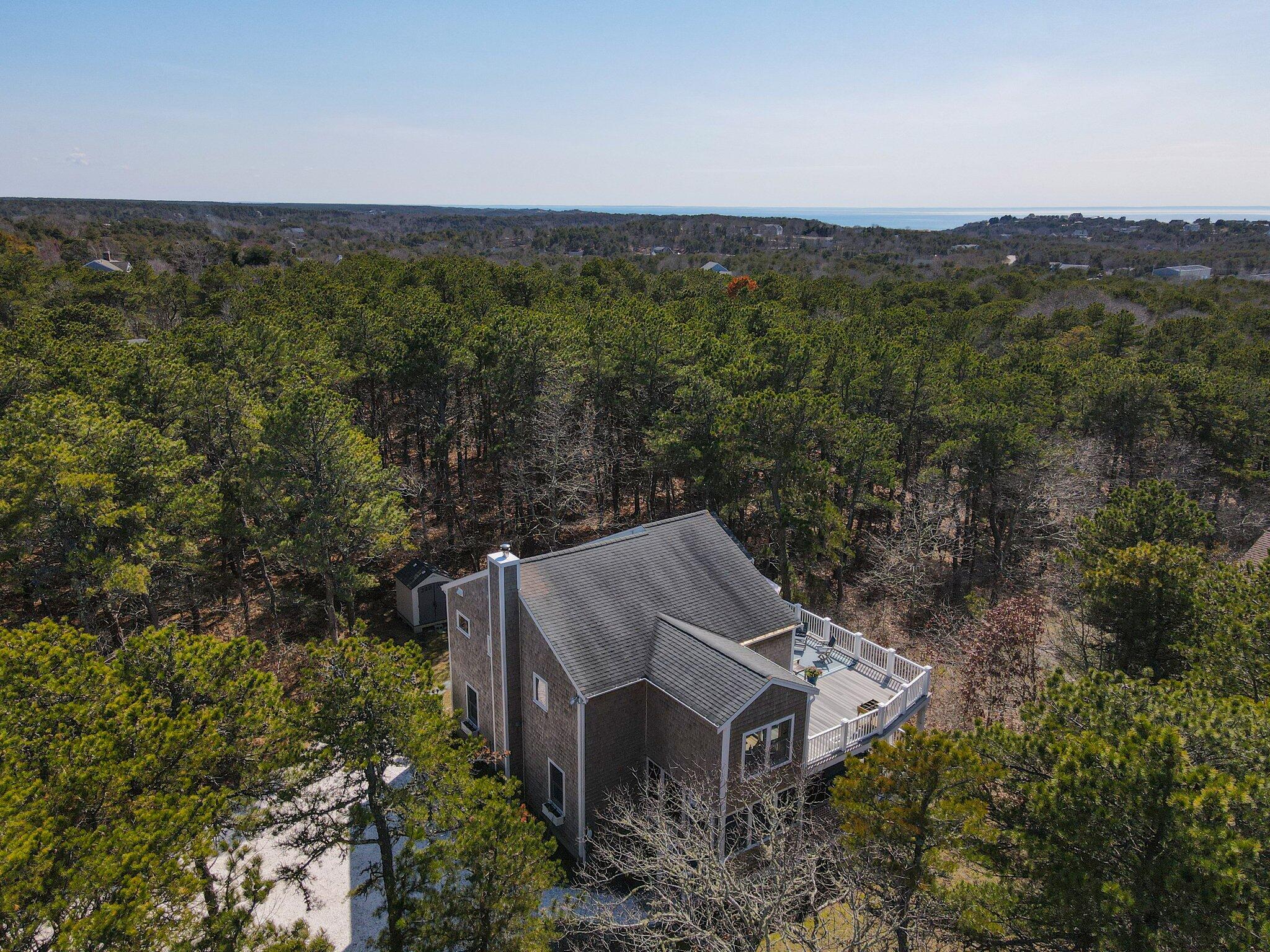 a view of a house with a yard and large trees