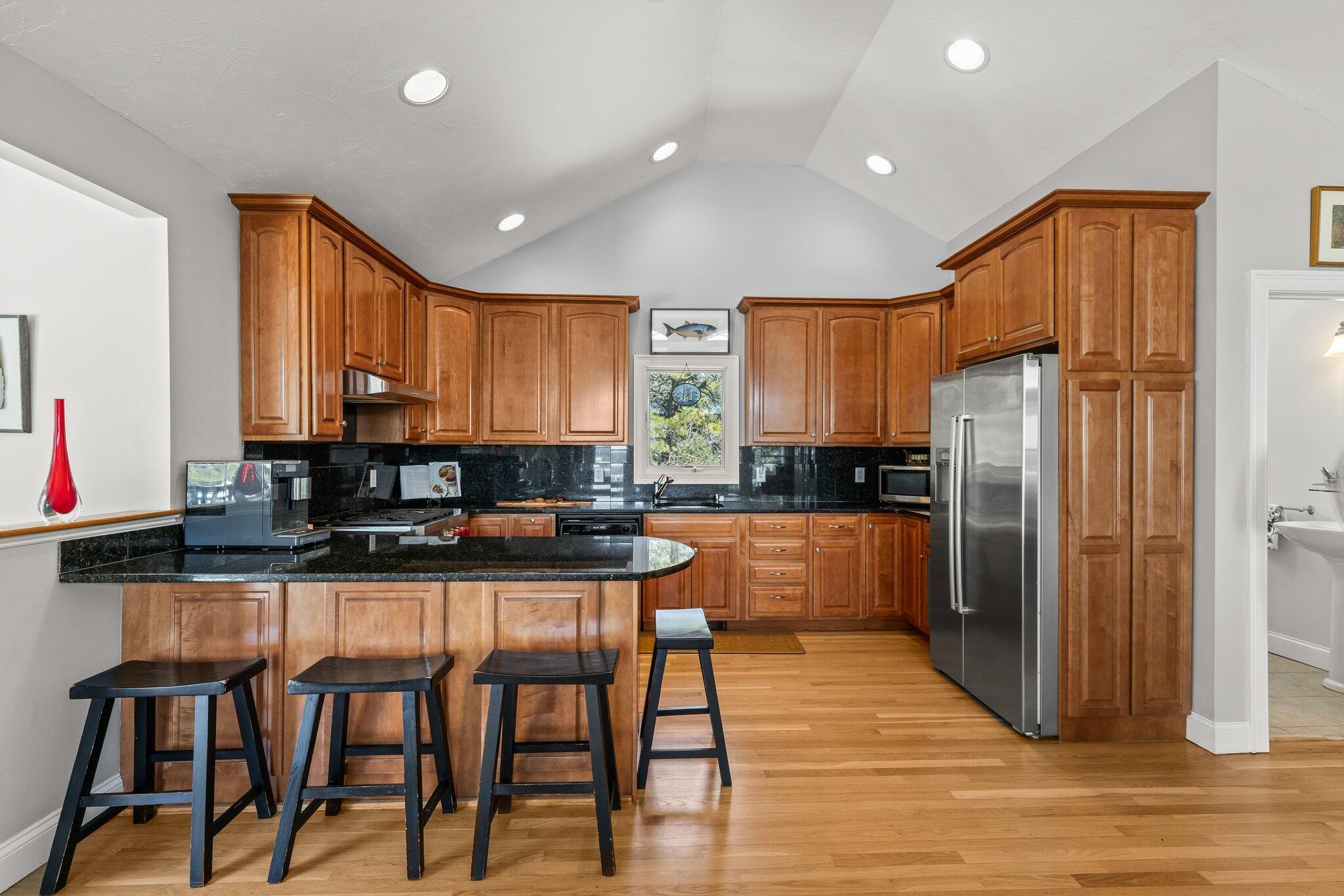 6 Short Lots Lane Truro, MA 02666 - Photo 27 of 63 a kitchen with stainless steel appliances granite countertop a refrigerator a sink dishwasher a stove and a dining table with wooden floor