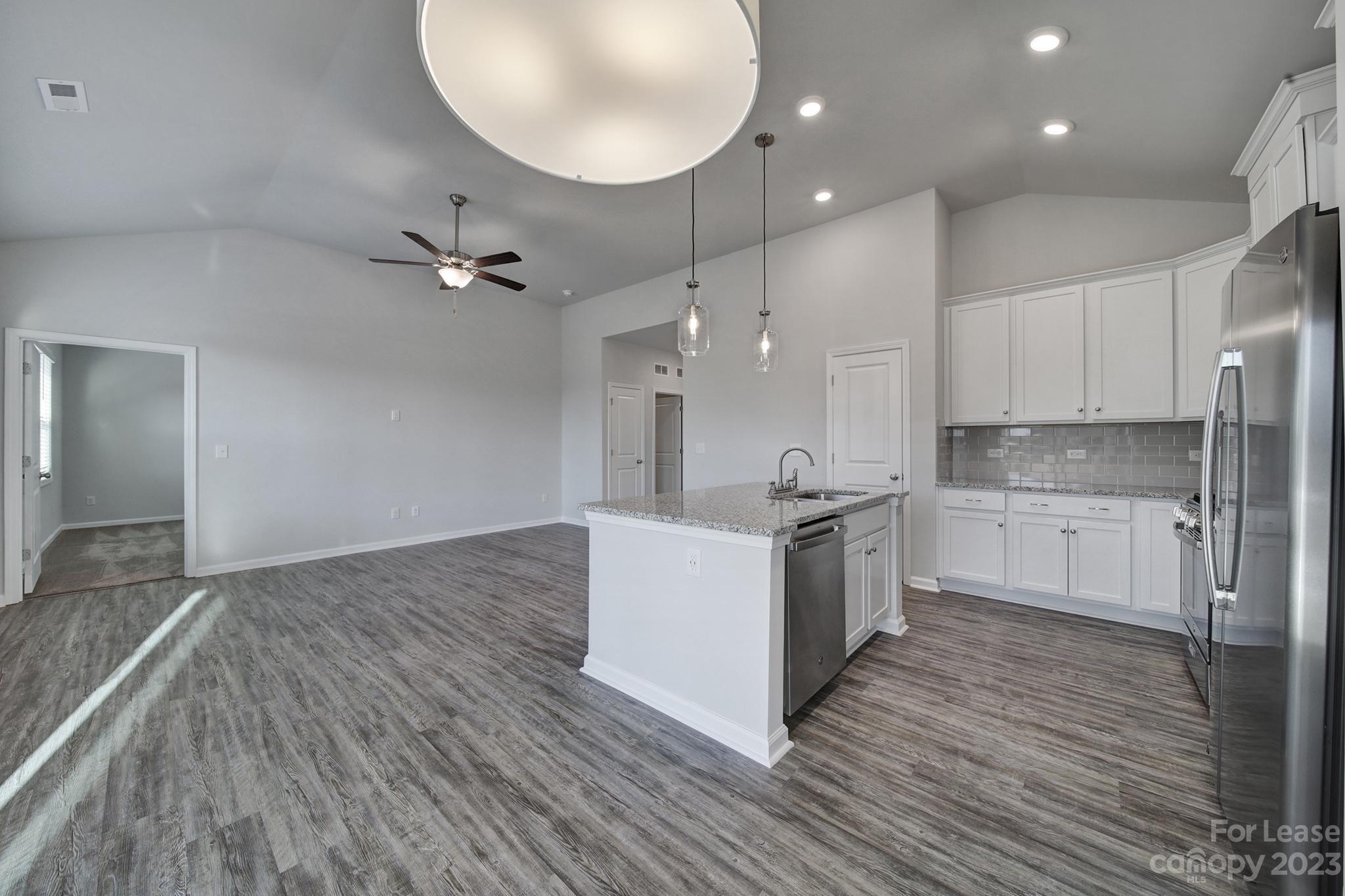 8201 Mccormick Street Terrell, NC 28682 - Photo 14 of 28 a large kitchen with stainless steel appliances kitchen island a large counter top and wooden floors