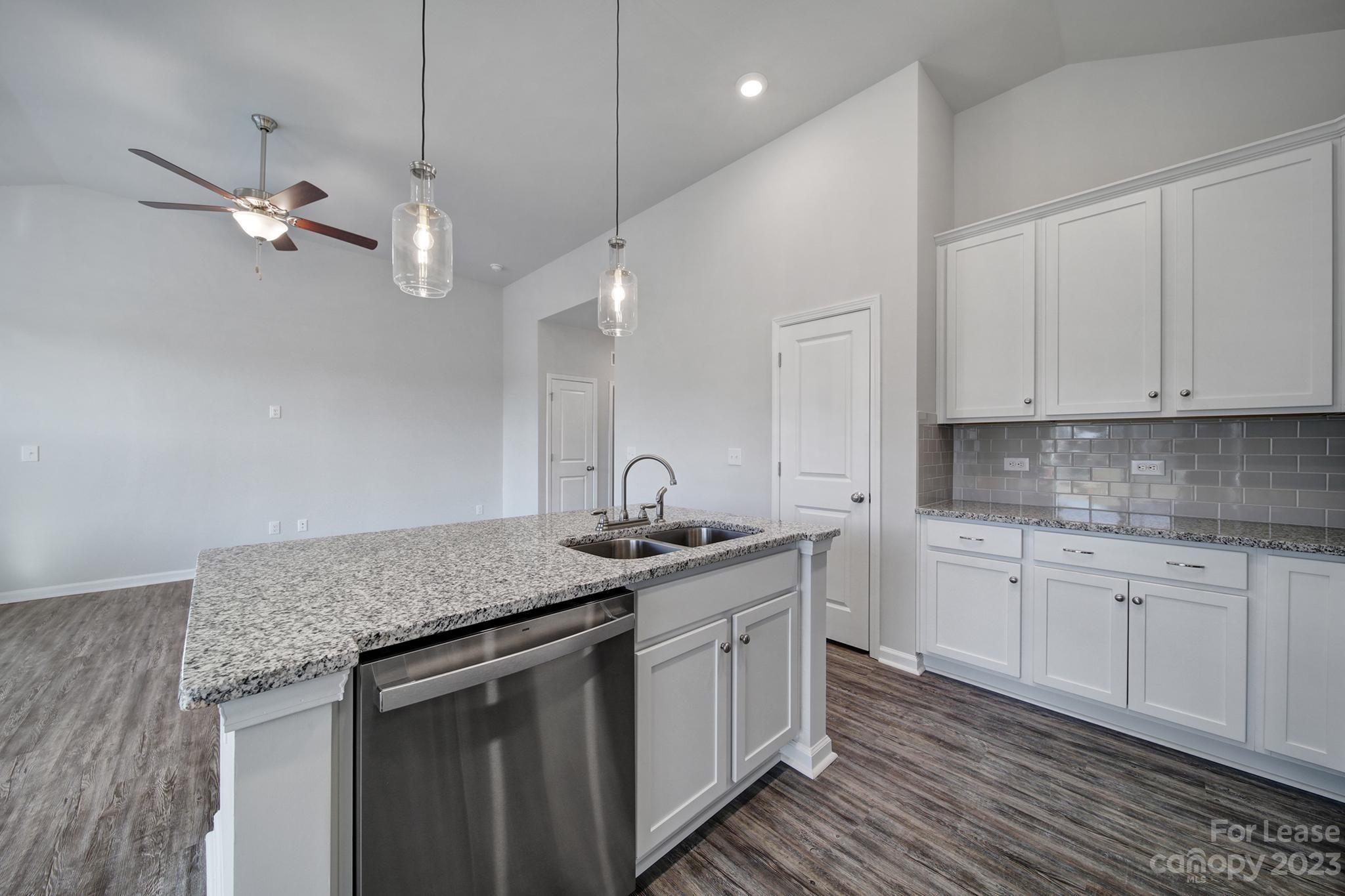 8201 Mccormick Street Terrell, NC 28682 - Photo 16 of 28 a kitchen with stainless steel appliances granite countertop a sink dishwasher a stove and white cabinets with wooden floor
