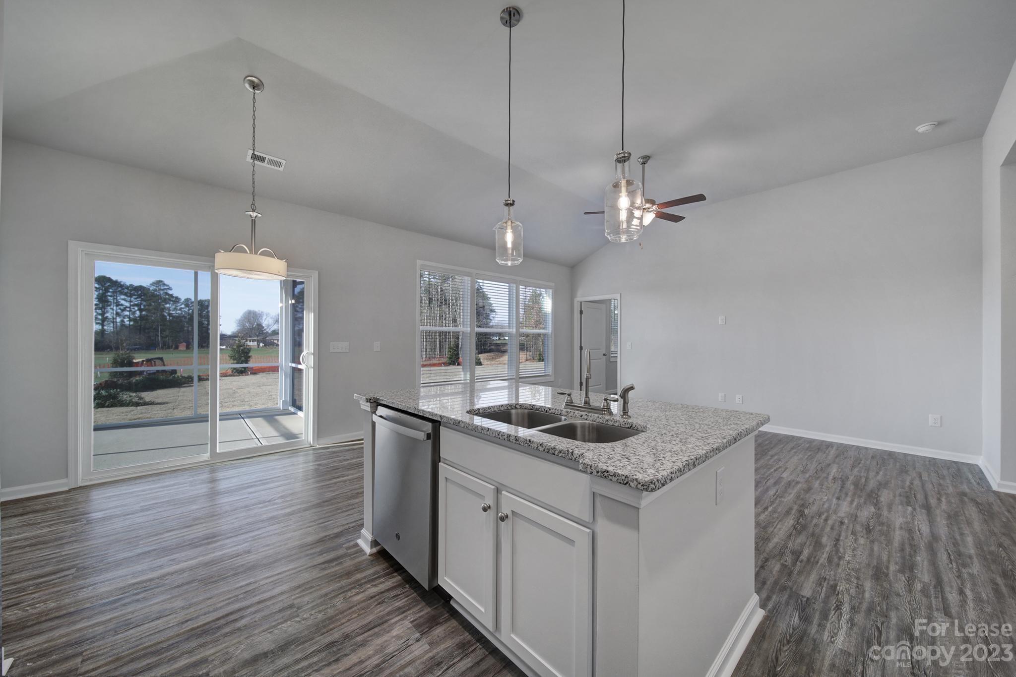 8201 Mccormick Street Terrell, NC 28682 - Photo 17 of 28 a kitchen with stainless steel appliances granite countertop a sink cabinets and wooden floor
