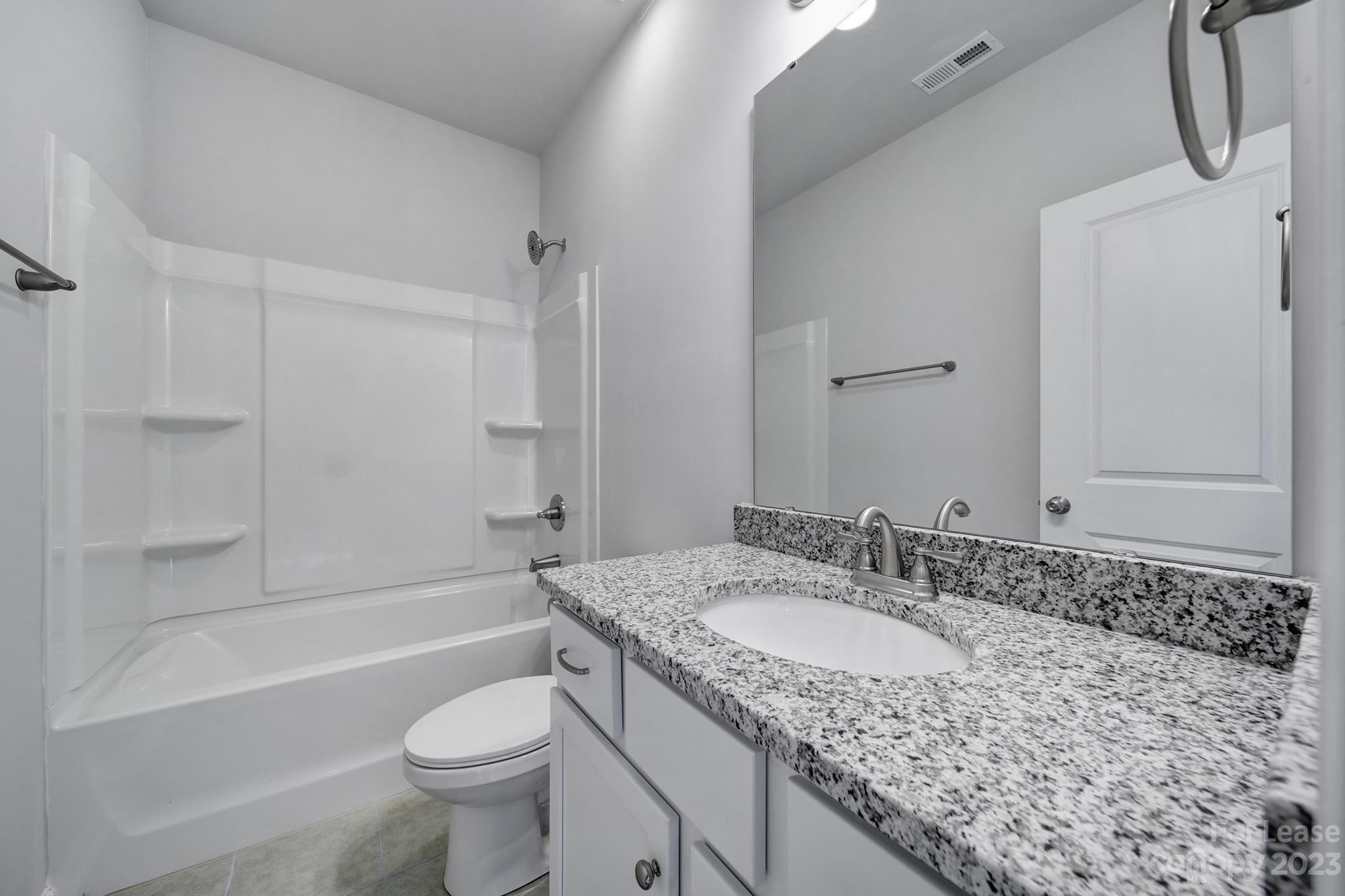 8201 Mccormick Street Terrell, NC 28682 - Photo 7 of 28 a bathroom with a granite countertop sink a toilet and bathtub