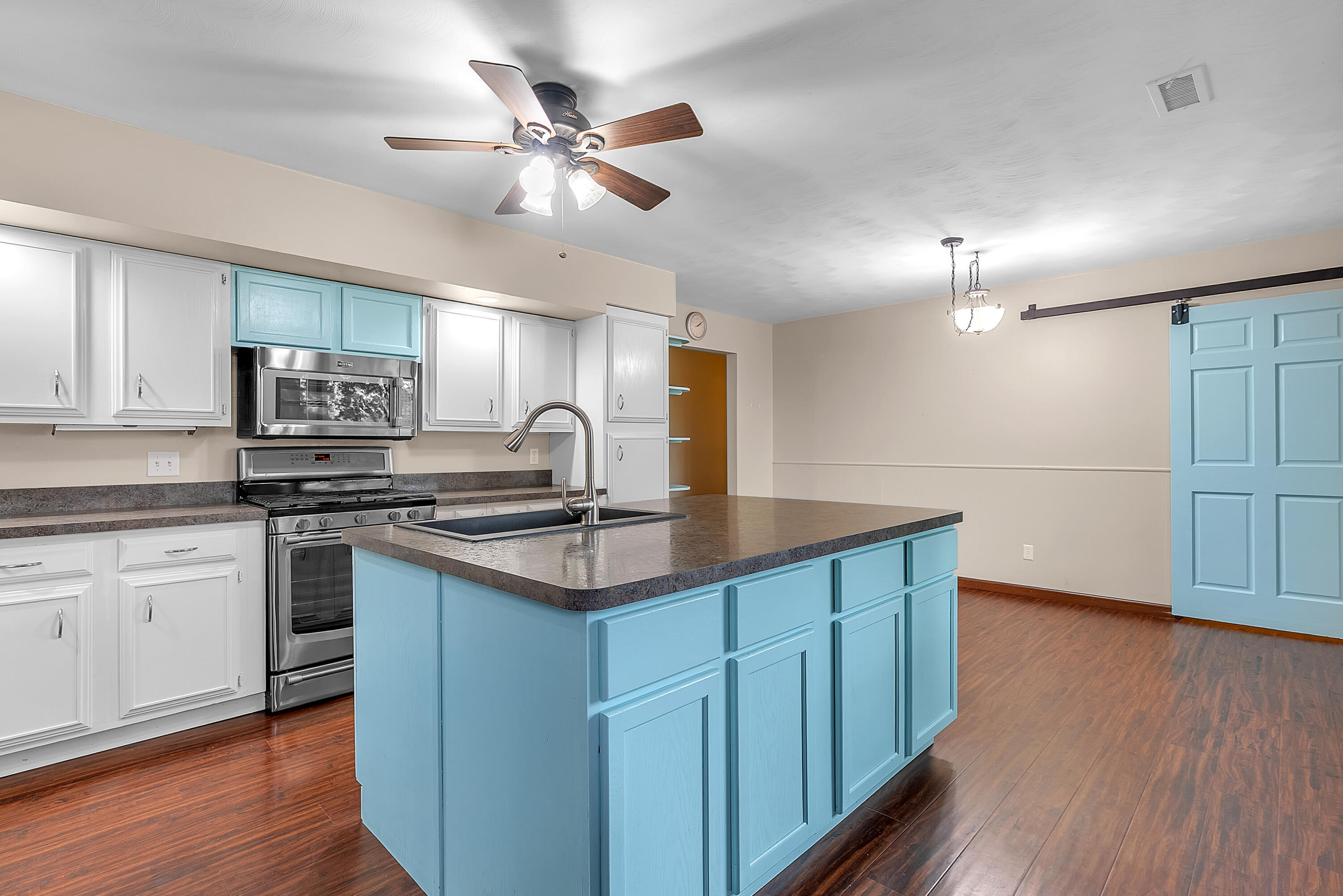 2204 South Meridian Road Morocco, IN 47963 - Photo 9 of 35 a kitchen with stainless steel appliances granite countertop a sink a stove a refrigerator cabinets and wooden floor