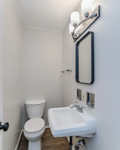 a bathroom with a toilet sink and mirror