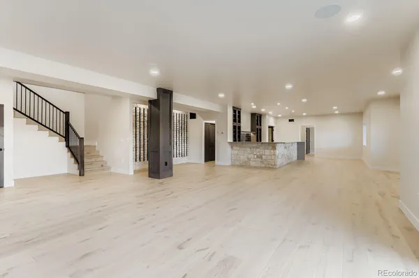 a living room with stainless steel appliances furniture a refrigerator and kitchen view