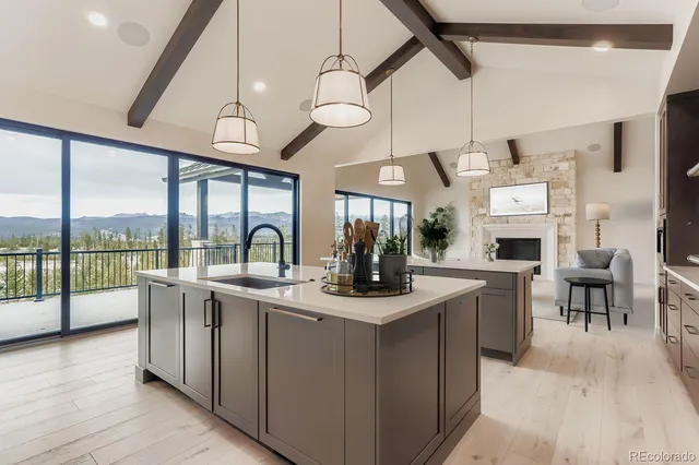 a large kitchen with stainless steel appliances granite countertop a large kitchen island a stove and a view of living room