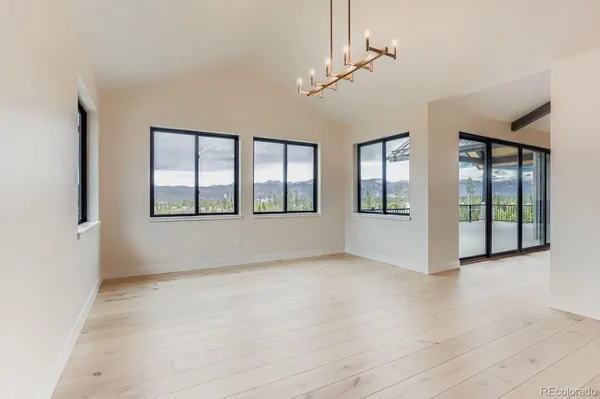 a view of an empty room with wooden floor fireplace and a window