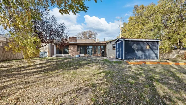 a view of a house with backyard and trees