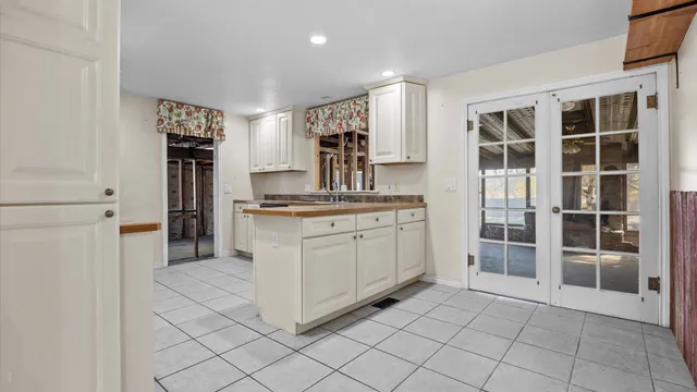 a kitchen with white cabinets and refrigerator
