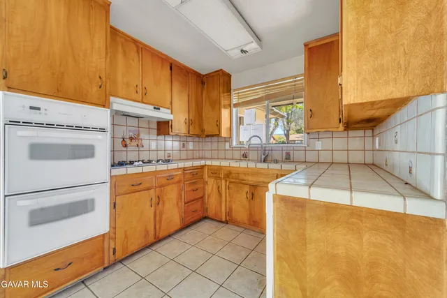 a kitchen with sink cabinets and a stove top oven