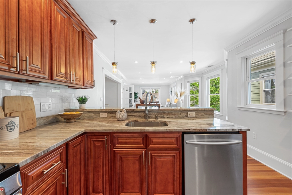 24 Jackson Road, Unit 2 Somerville, MA 02145 - Photo 11 of 35 a kitchen with kitchen island granite countertop a sink cabinets and window