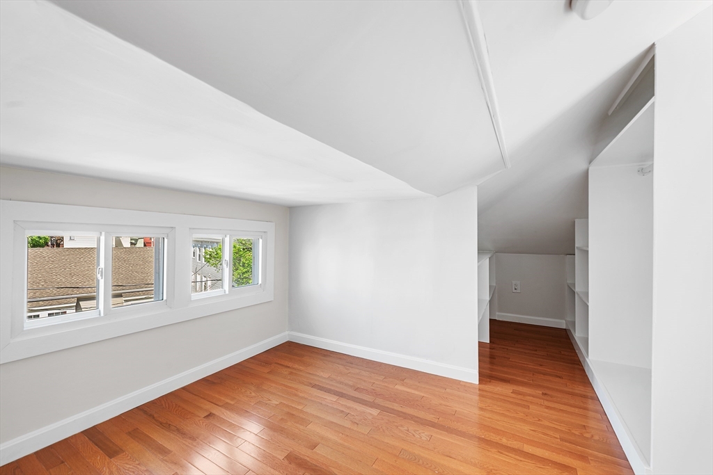 24 Jackson Road, Unit 2 Somerville, MA 02145 - Photo 27 of 35 a view of an empty room with wooden floor and a window