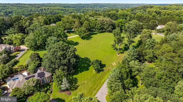 an aerial view of residential houses with outdoor space and trees