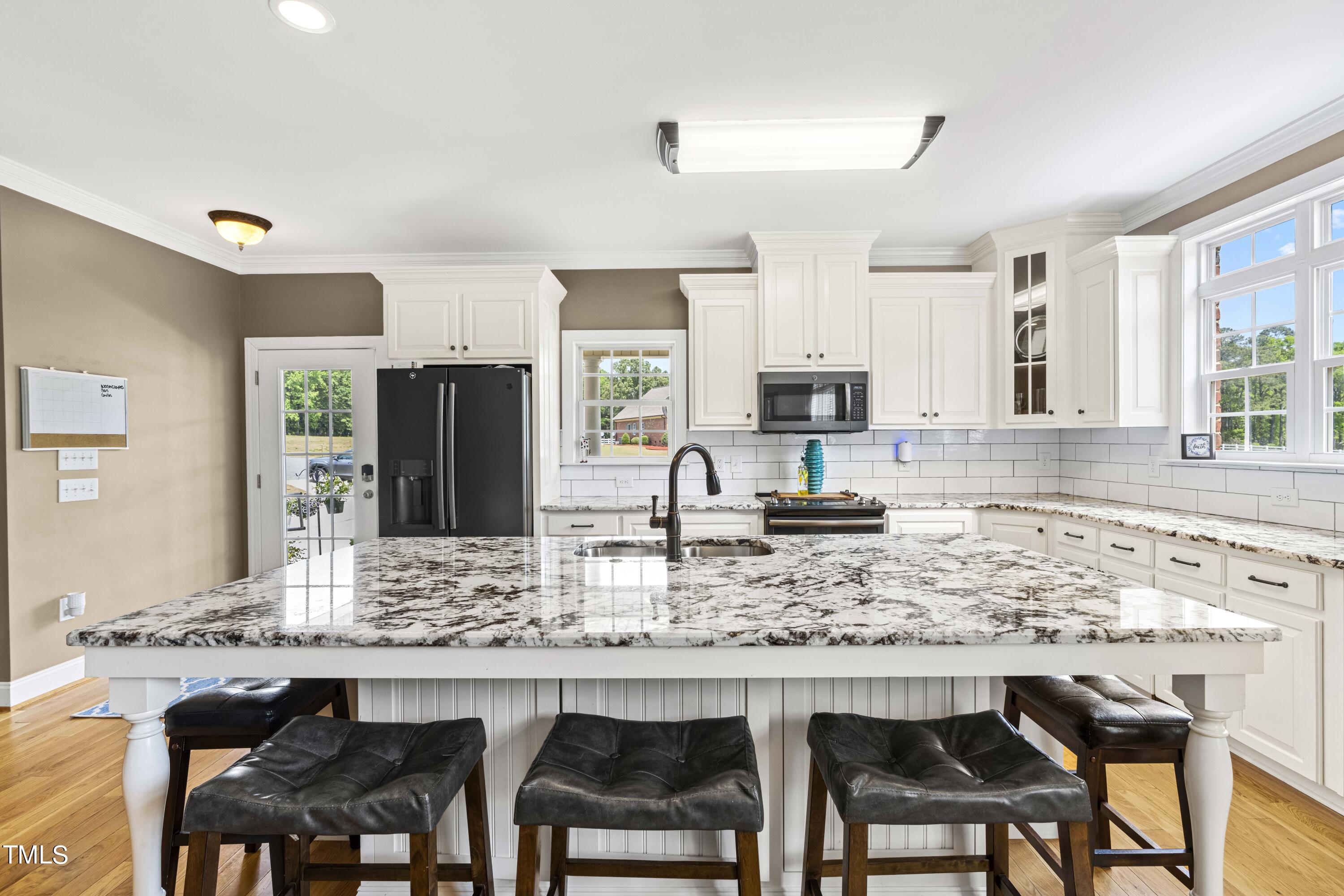 115 Three M Trail Benson, NC 27504 - Photo 16 of 80 a kitchen with granite countertop a table chairs sink and cabinets