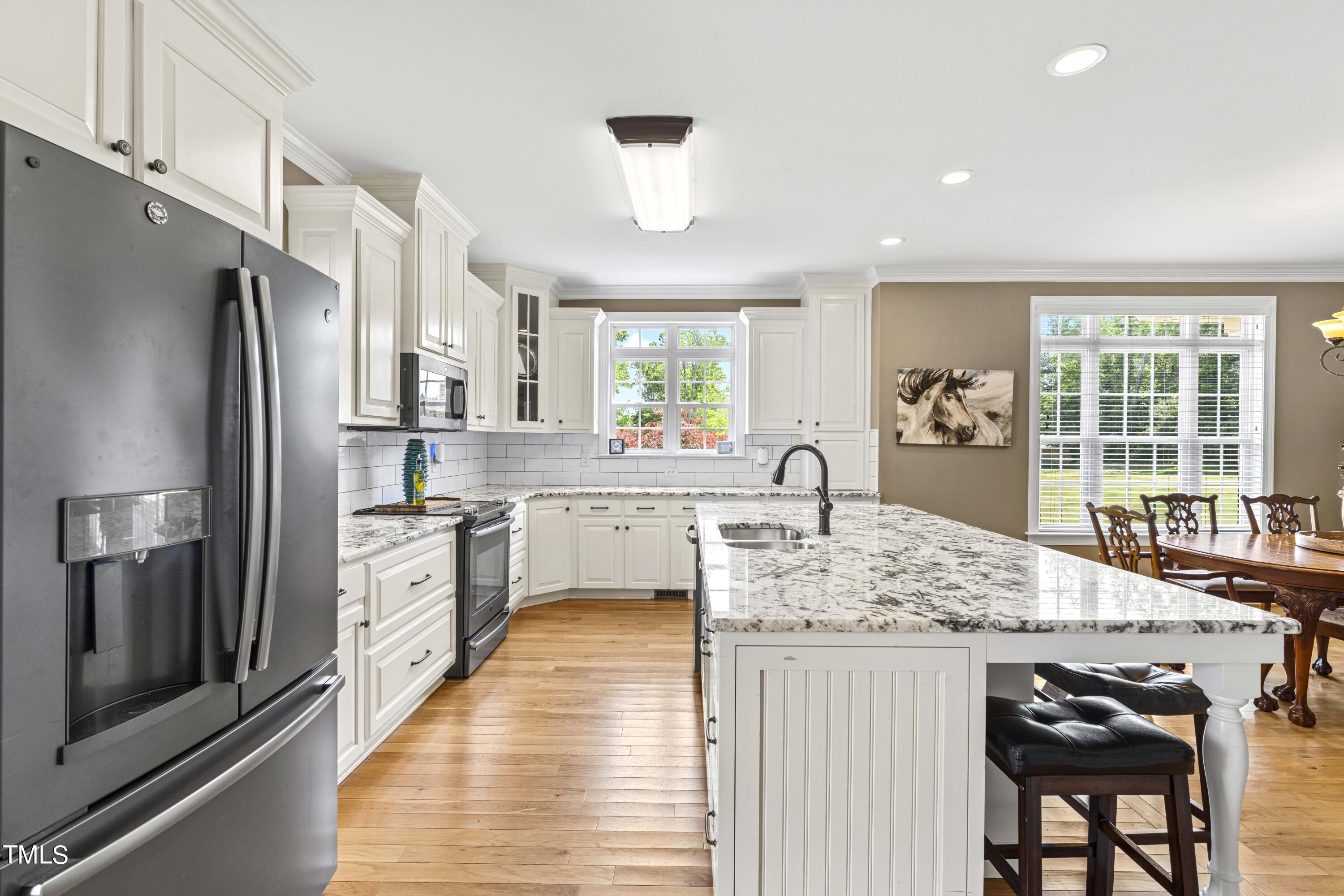115 Three M Trail Benson, NC 27504 - Photo 20 of 80 a large kitchen with kitchen island a large counter top space a sink stainless steel appliances and windows
