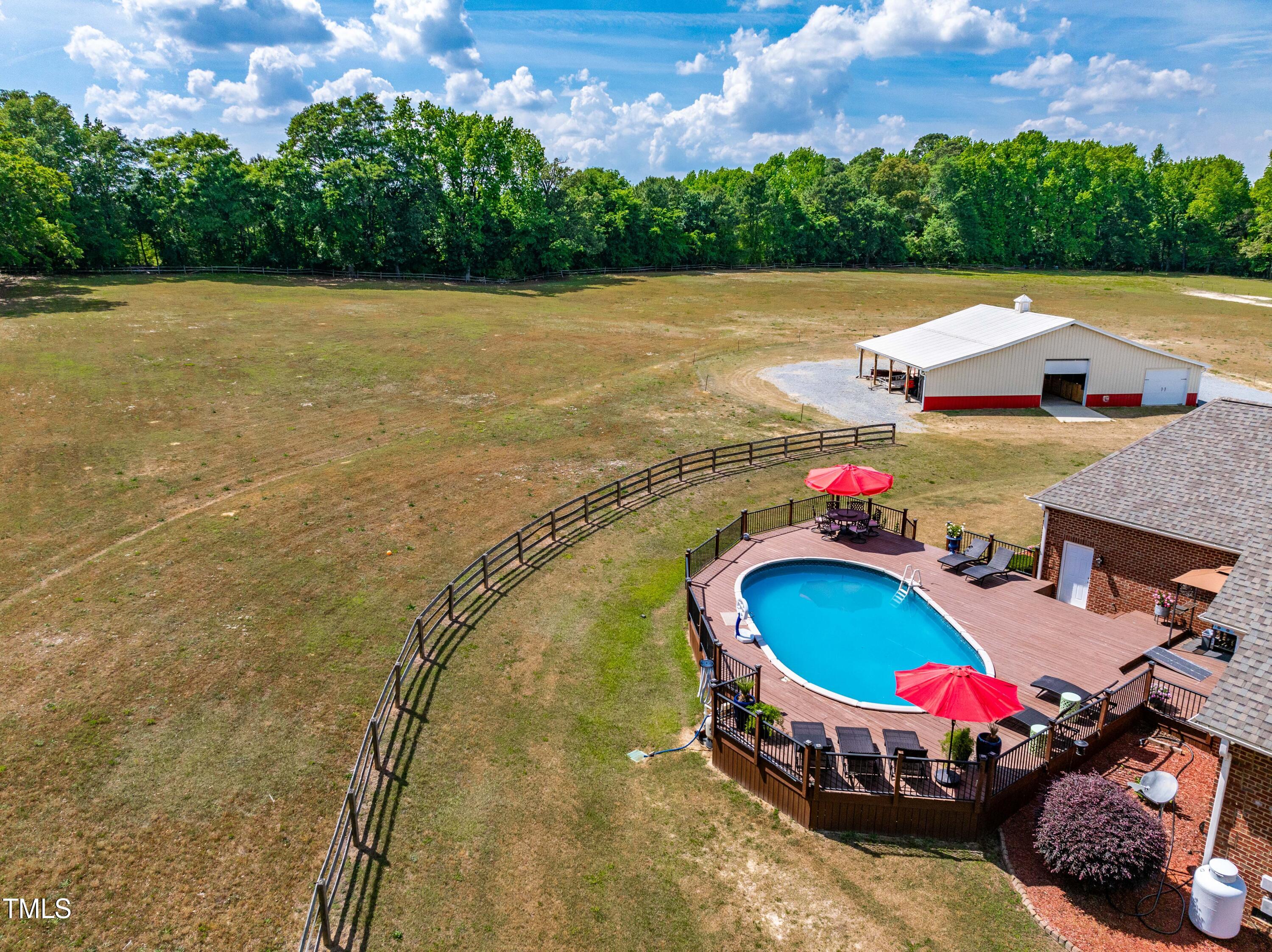 115 Three M Trail Benson, NC 27504 - Photo 44 of 80 a view of swimming pool with seating space and trees in the background
