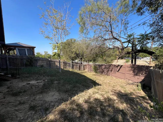 a view of a backyard with wooden fence