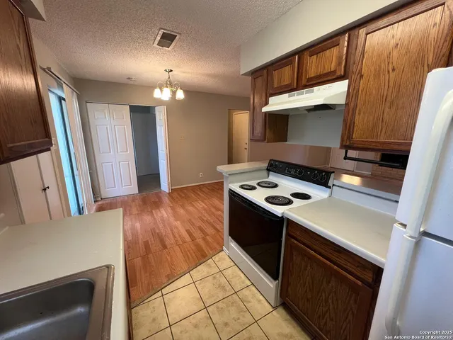 a kitchen with wooden cabinets and a stove top oven
