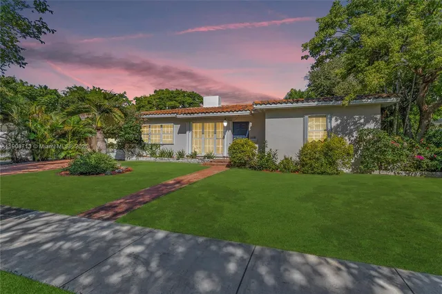 a front view of a house with a garden and yard