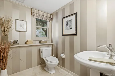 a bathroom with a toilet a sink and mirror