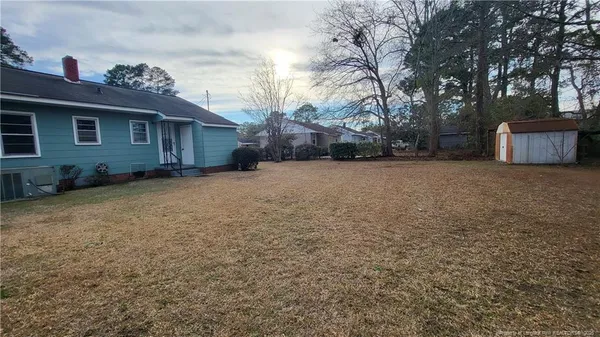 a view of a house with a large tree and a yard