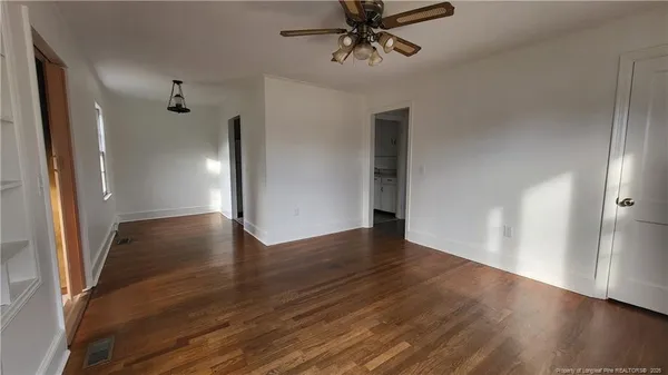 an empty room with wooden floor and entryway